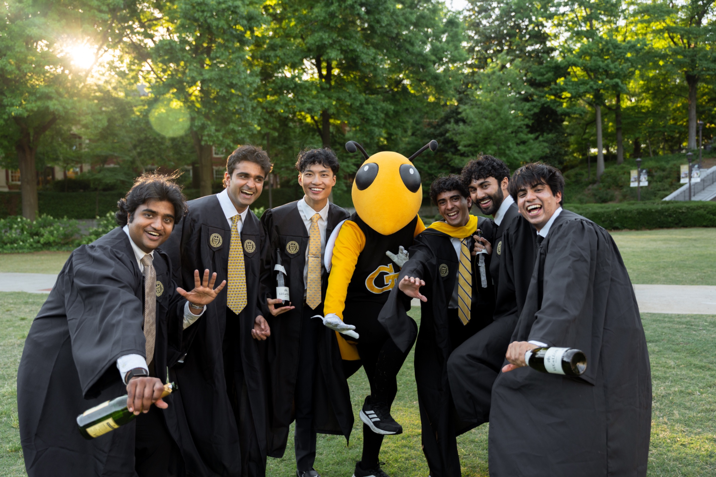 Grads crowded around Buzz on the front lawn, Tech Tower over their shoulders